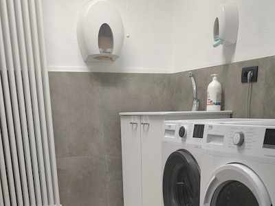 Sala lavanderia self service con lavatrice e asciugatrice ad uso gratuito